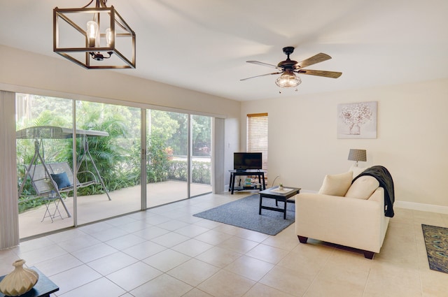 living room with light tile patterned flooring and ceiling fan with notable chandelier