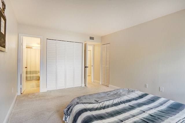 bedroom featuring light carpet and connected bathroom