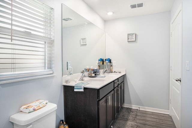 bathroom featuring wood-type flooring, vanity, and toilet