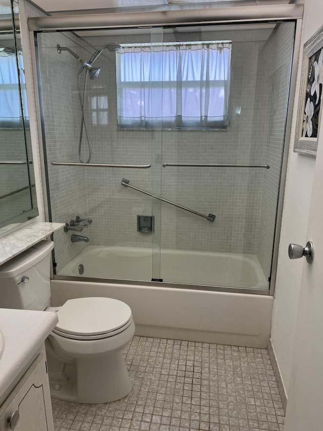 full bathroom featuring a healthy amount of sunlight, vanity, enclosed tub / shower combo, and toilet