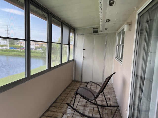 sunroom / solarium with lofted ceiling, a water view, and plenty of natural light