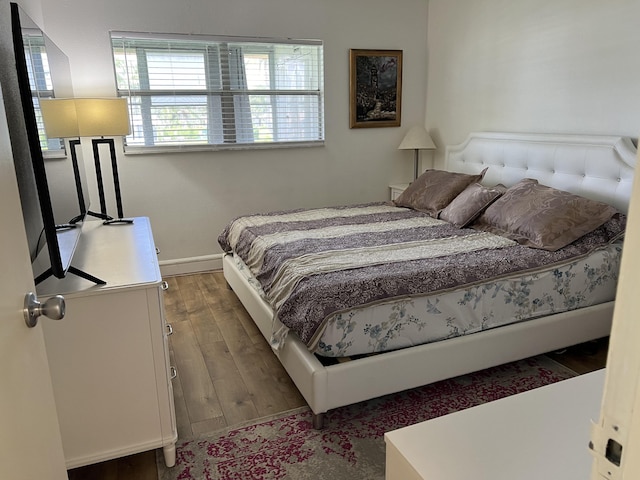 bedroom with dark wood-type flooring