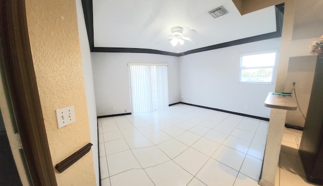 tiled spare room with crown molding and ceiling fan