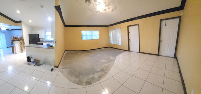 tiled entryway featuring vaulted ceiling and crown molding