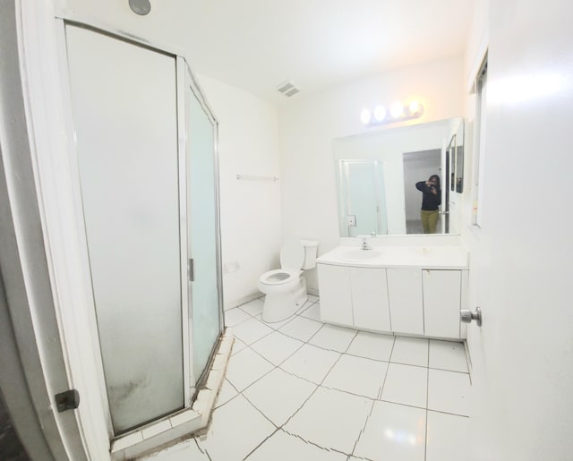 bathroom featuring tile patterned floors, vanity, toilet, and an enclosed shower