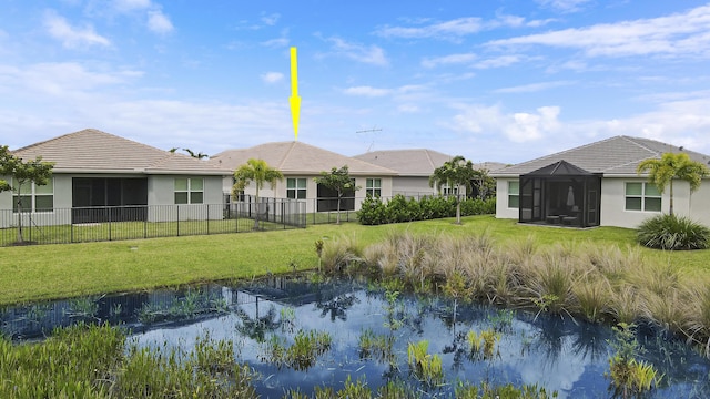 back of property with a yard and a sunroom