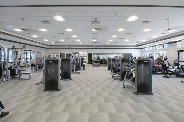 workout area with a paneled ceiling and light colored carpet