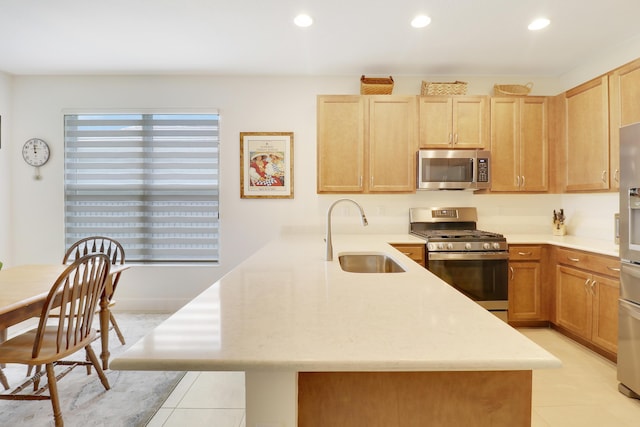 kitchen with sink, appliances with stainless steel finishes, light tile patterned flooring, kitchen peninsula, and light brown cabinets