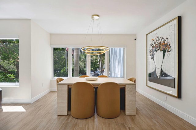 dining space featuring light hardwood / wood-style floors and a notable chandelier