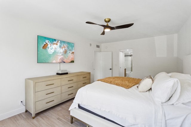 bedroom featuring ensuite bath, light hardwood / wood-style flooring, and ceiling fan