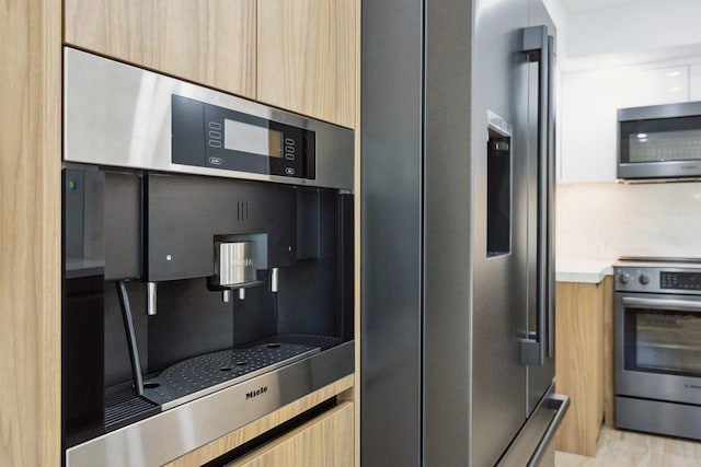 kitchen with light brown cabinetry and stainless steel appliances