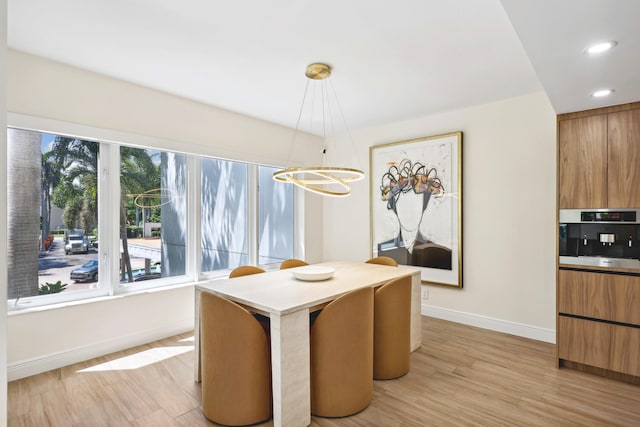 dining area with a chandelier and light wood-type flooring