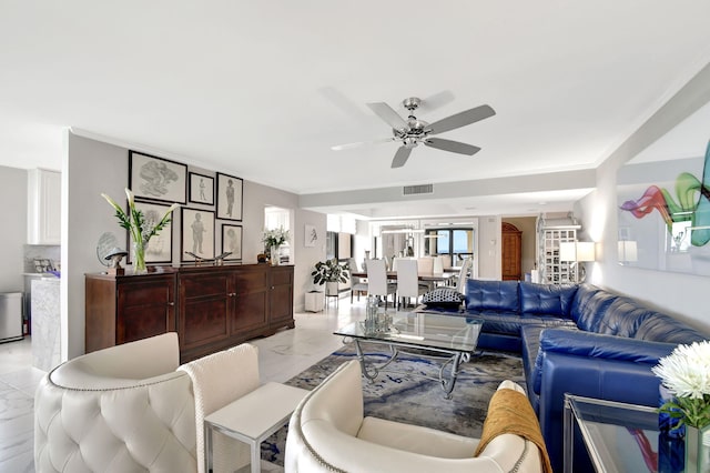 living room with ornamental molding and ceiling fan