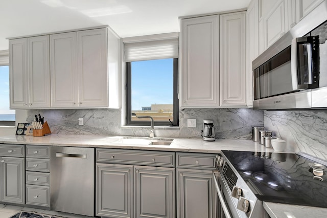 kitchen with gray cabinetry, plenty of natural light, stainless steel appliances, and sink