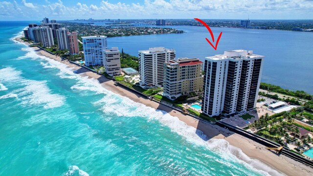 birds eye view of property with a water view and a beach view