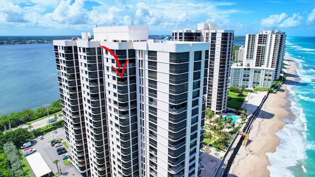 view of building exterior featuring a water view and a view of the beach