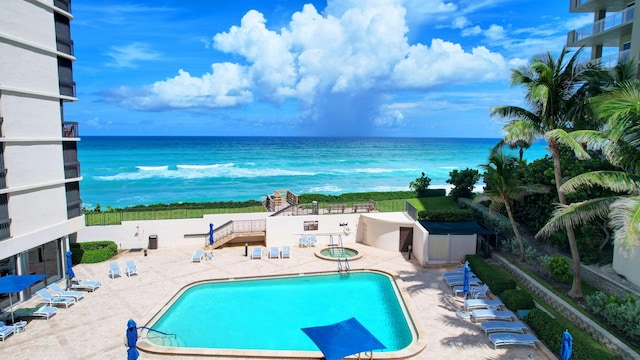 view of swimming pool featuring a water view and a patio area