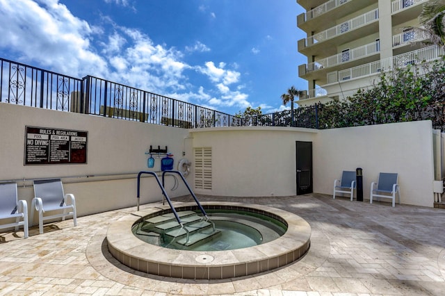 view of swimming pool with a hot tub and a patio area