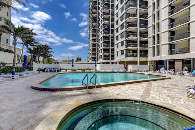 view of pool with a hot tub and a patio