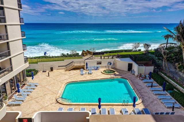 view of swimming pool with a water view and a patio