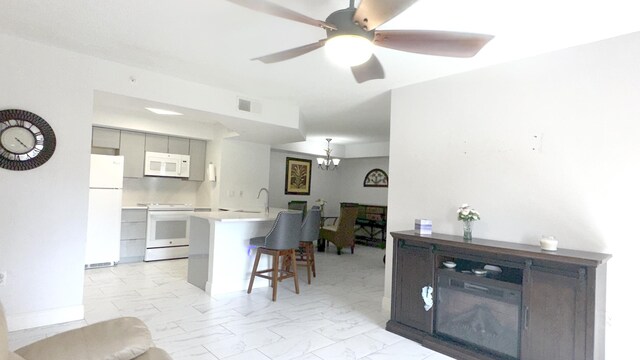 interior space featuring ceiling fan with notable chandelier and sink