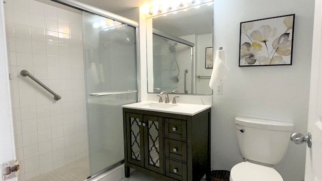 bathroom featuring vanity, toilet, and an enclosed shower