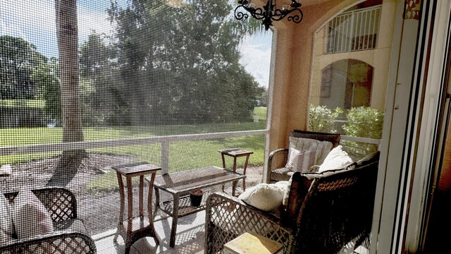 sunroom with plenty of natural light and a notable chandelier