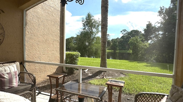 sunroom featuring a water view