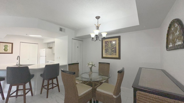 dining area with a notable chandelier and sink