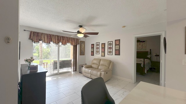 living room featuring a textured ceiling and ceiling fan