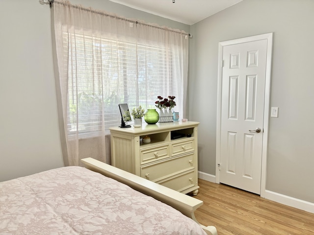 bedroom with light wood-type flooring and vaulted ceiling