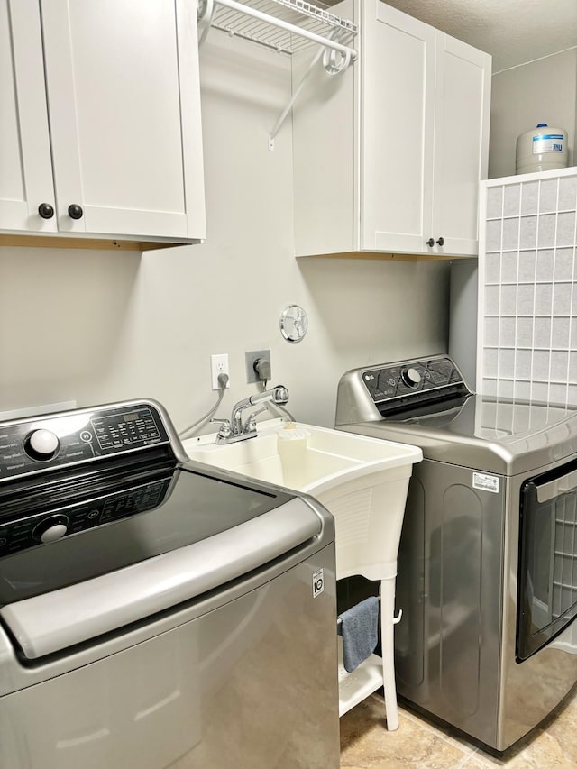 laundry area featuring washing machine and clothes dryer and cabinets