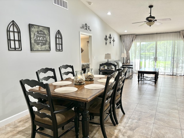 dining space featuring ceiling fan, light tile patterned floors, and vaulted ceiling