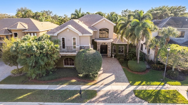 view of front of house with a balcony and a front yard