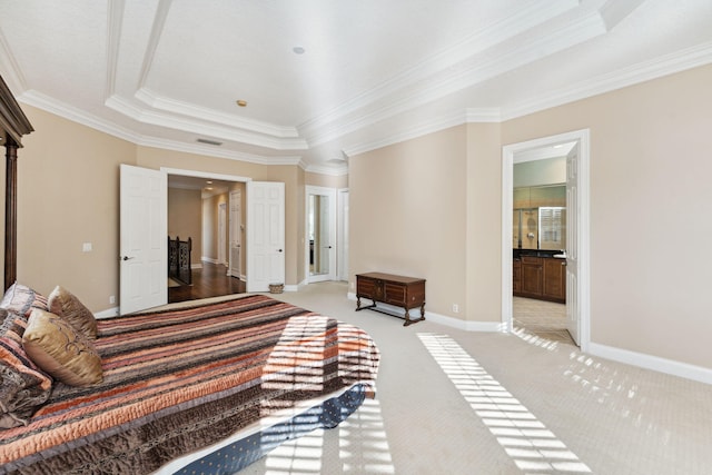 bedroom with ornamental molding, light carpet, and ensuite bath