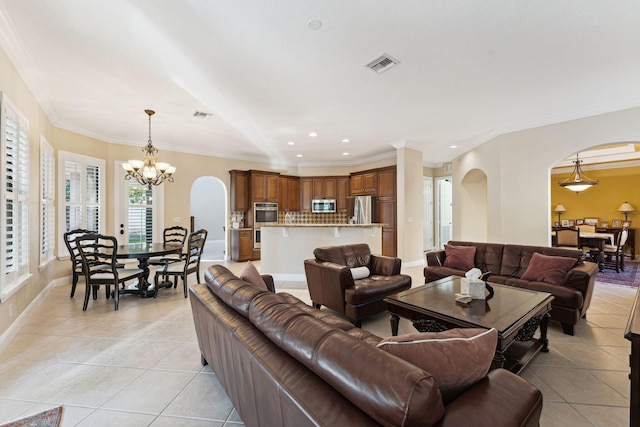 tiled living room featuring ornamental molding and a notable chandelier