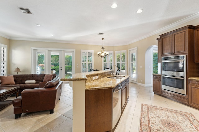 kitchen with light tile patterned floors, appliances with stainless steel finishes, a wealth of natural light, and sink