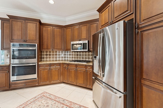 kitchen with crown molding, light tile patterned floors, light stone counters, and stainless steel appliances