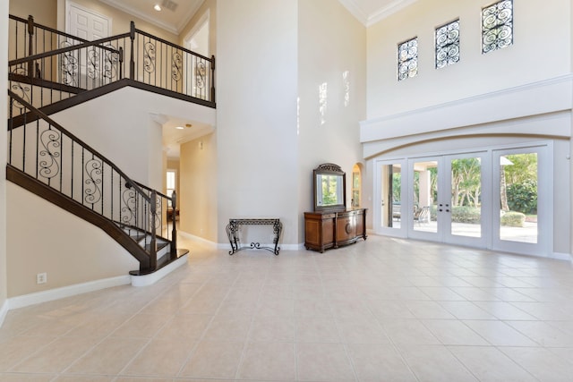 interior space featuring a towering ceiling, french doors, and crown molding