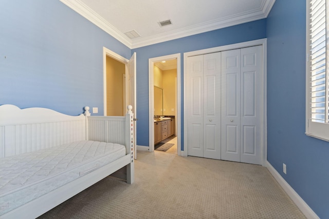 carpeted bedroom with ornamental molding, connected bathroom, and a closet