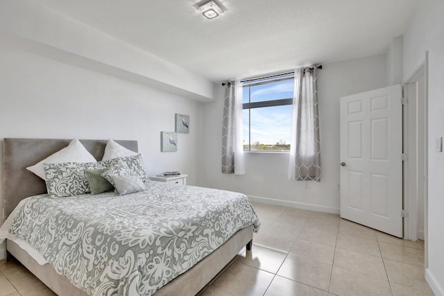 bedroom with light tile patterned floors and a textured ceiling