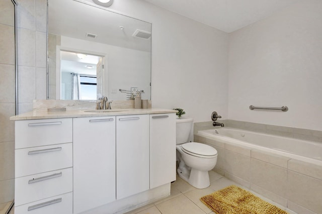 bathroom featuring vanity, toilet, a relaxing tiled tub, and tile patterned flooring