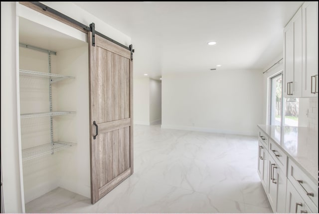 interior space featuring a barn door and white cabinets