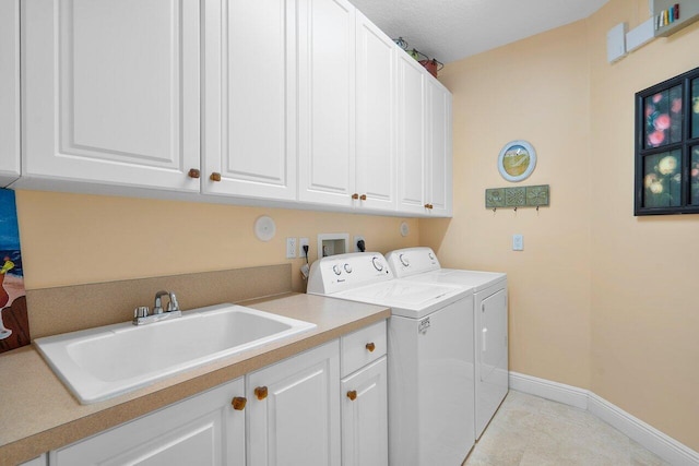 washroom with washing machine and clothes dryer, cabinets, sink, and light tile patterned floors