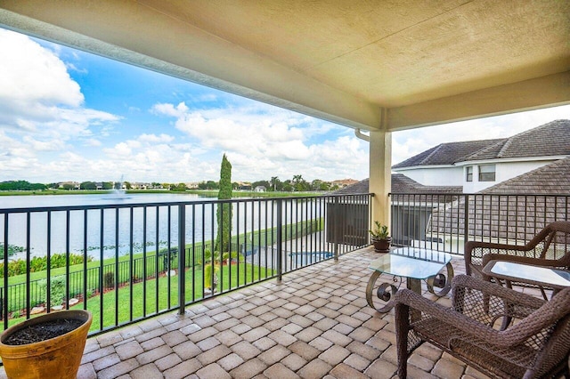 view of patio with a balcony and a water view