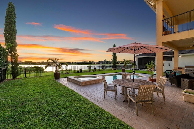 exterior space with a lawn, a water view, outdoor lounge area, a pool with hot tub, and a balcony