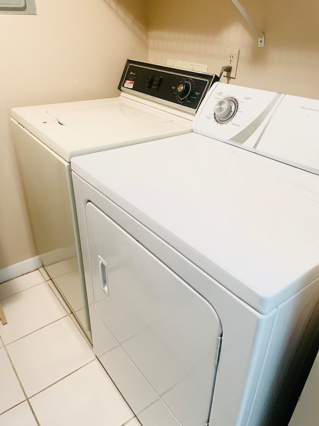 clothes washing area featuring washing machine and clothes dryer and light tile patterned flooring