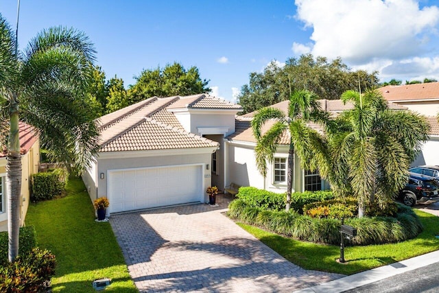 mediterranean / spanish house featuring a garage and a front lawn