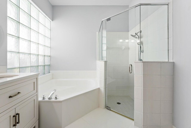 bathroom featuring tile patterned flooring, shower with separate bathtub, and vanity