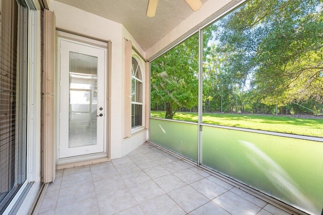 unfurnished sunroom with ceiling fan and vaulted ceiling